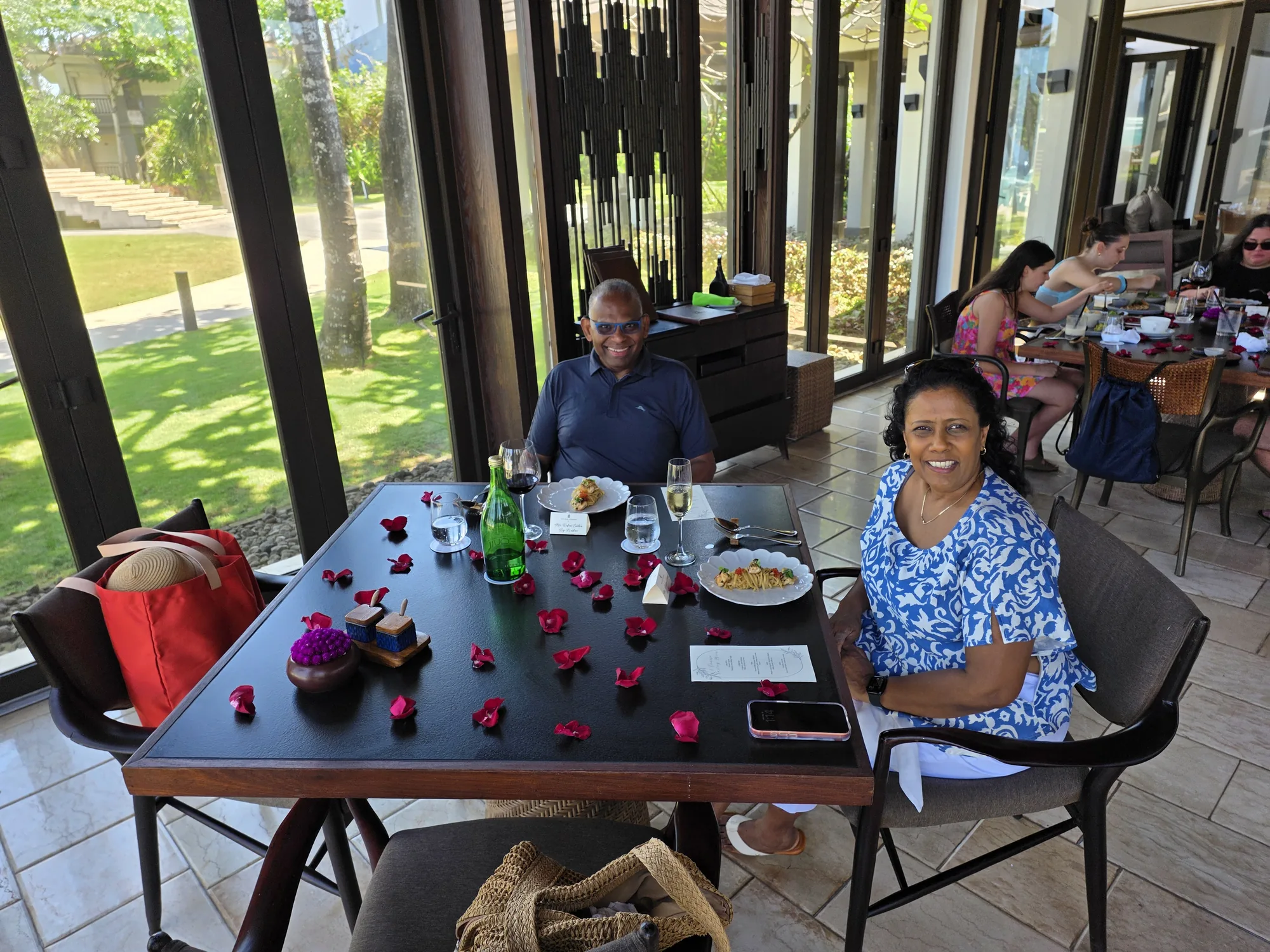 Robert and Ruky seated at their rose-petal lunch table